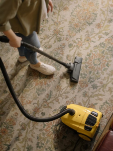 a person doing vacuum over a carpet
